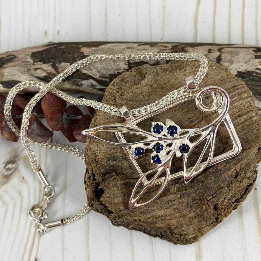 Blueberry Branch Necklace And Earrings Set. Handcrafted by Linda Stiles Smith of NatureScapes Studio in pure fine silver with blue sapphire cabochons accents. Front Angled View. Collectible One Of A Kind Gift For Women.
