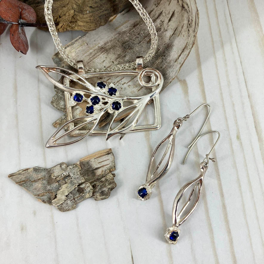 Blueberry Branch Necklace And Earrings Set. Handcrafted by Linda Stiles Smith of NatureScapes Studio in pure fine silver with blue sapphire cabochons accents. Front View of the pendant and earrings. Collectible One Of A Kind Gift For Women.
