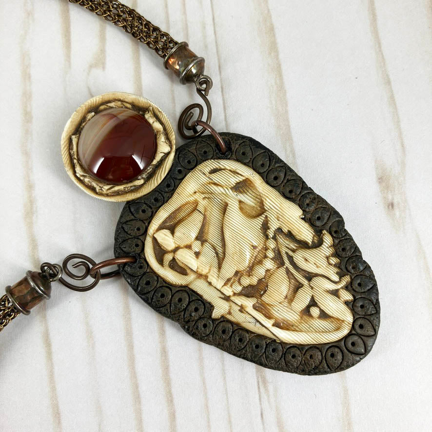 Faux Ivory Polymer Clay Pendant Necklace With Viking Knit Cord And Red Jasper Gemstone, Handmade By Linda Stiles Smith Of NatureScapes Studio. Close-up view of the pendant. Collectible Statement Necklace. Unique Gift For Women.