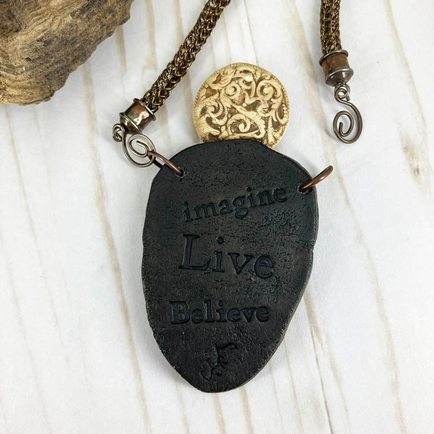 Faux Ivory Polymer Clay Pendant Necklace With Viking Knit Cord And Red Jasper Gemstone, Handmade By Linda Stiles Smith Of NatureScapes Studio. Close-up view of the back of the pendant. Collectible Statement Necklace. Unique Gift For Women.