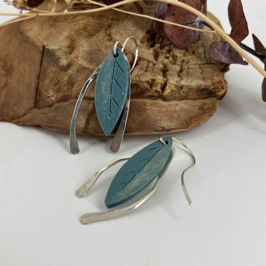 Gold dusted blue leaves captured with hammered sterling silver arches on both sides they are a one of a kind earring design by artist Linda Stiles Smith.