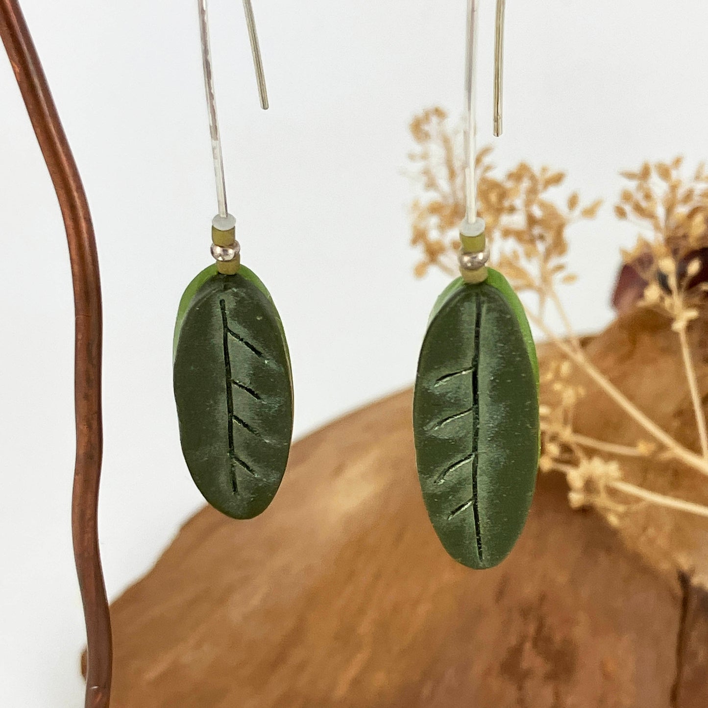 Multiple greens are featured in these oval leaf patterned earrings. By Linda Stiles Smith of NatureScapes Studio.