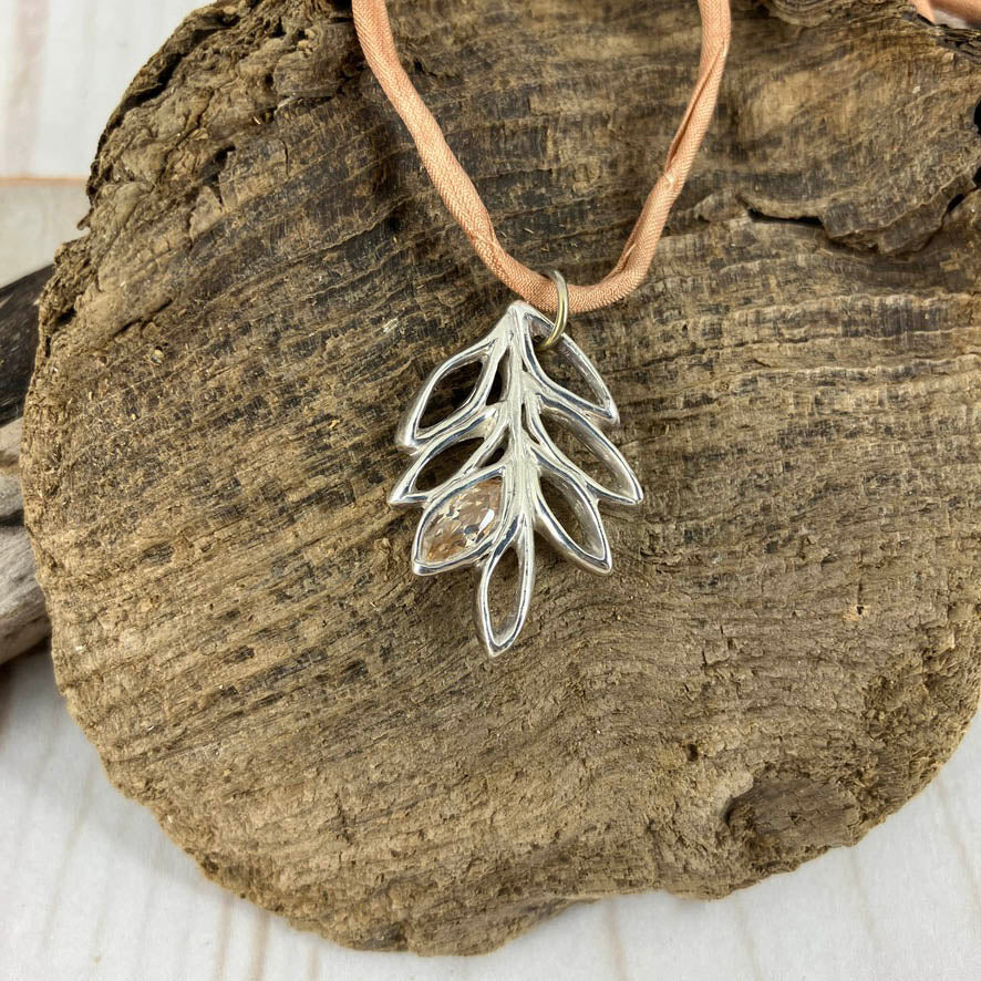 Leaf cluster outlined in fine silver with a champagne topaz gemstone in one petal on a ring handmade by Linda Stiles Smith of Naturescapes Studio. Delicate necklace for all age women.