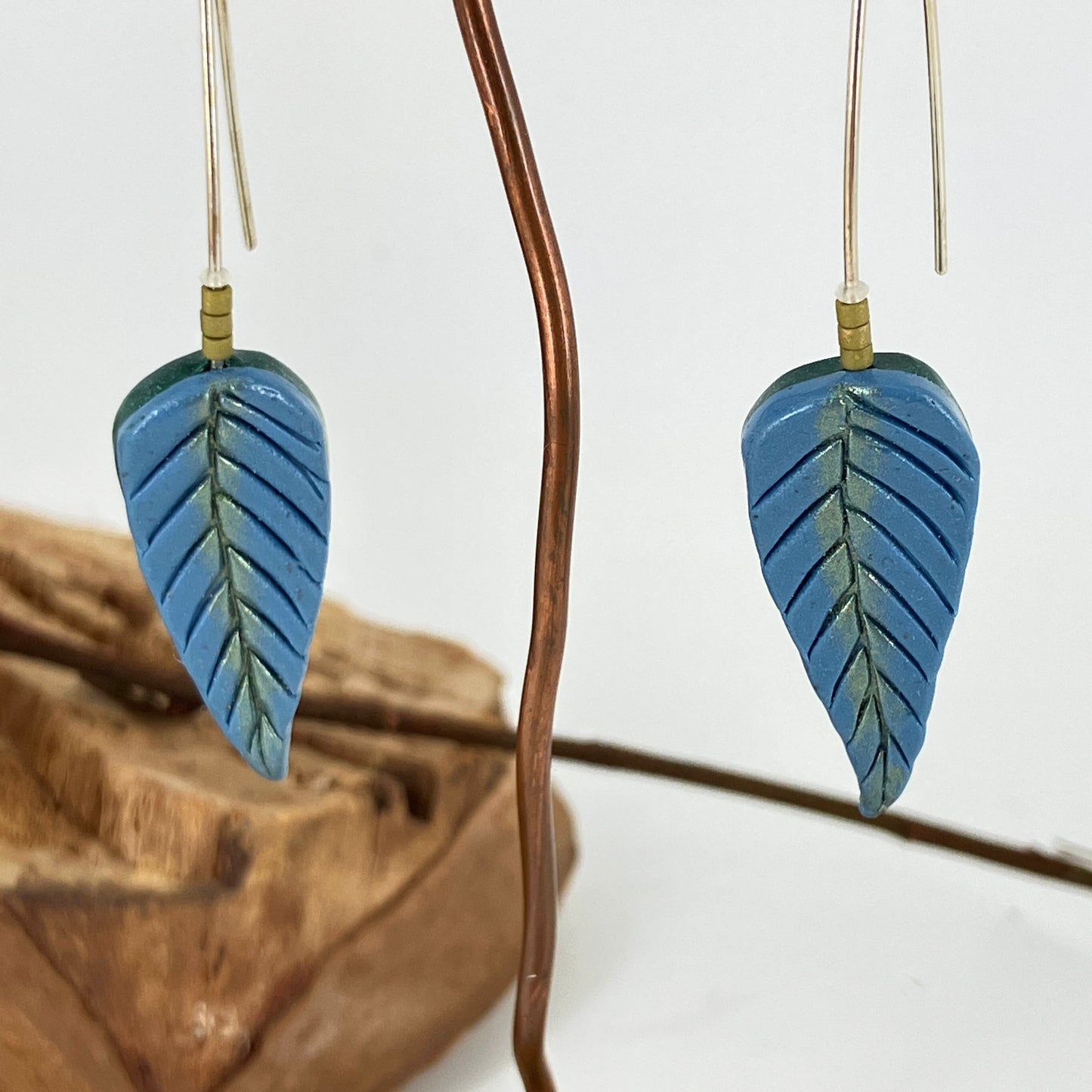 The handcrafted blue and green leaves of these earrings are a one of a kind design by Linda Stiles Smith of NatureScapes Studio.