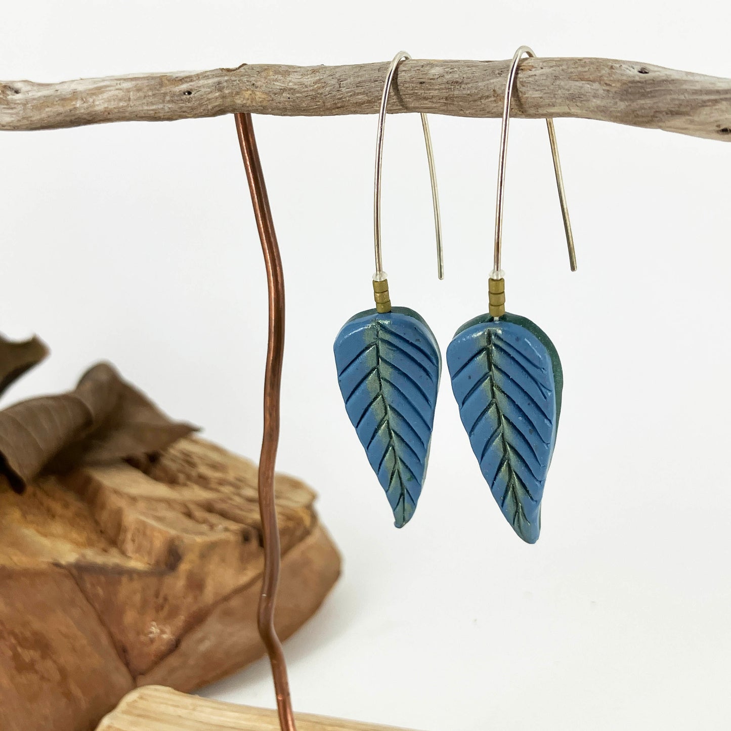 Stunning long hook earring design with blue leaves dusted with green shimmer designed by Linda Stiles Smith