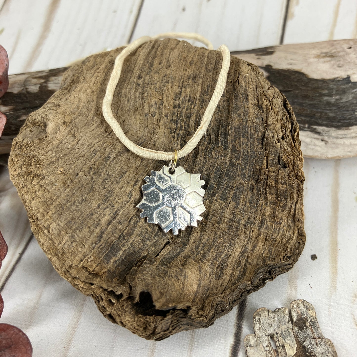 Snowflakes falling caught on a pendant with a fine silk necklace
