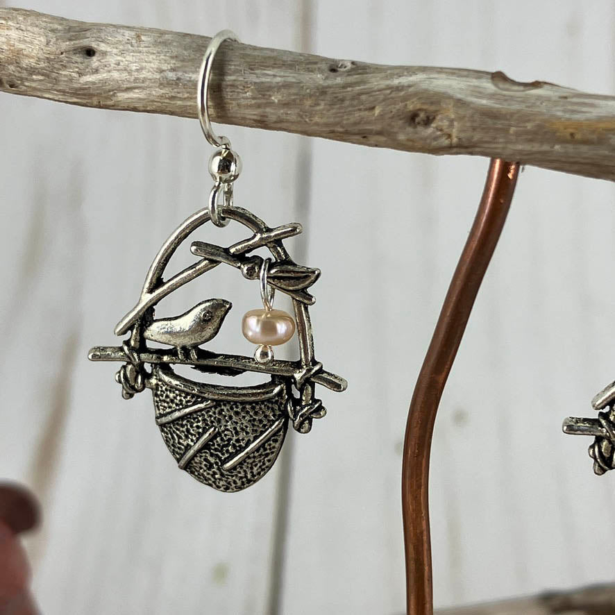 Close up of birdsnest charm and ivory pearl earrings. Charms hang on sterling silver hooks and look oh so sweet. Crafted at NatureScapes Studio