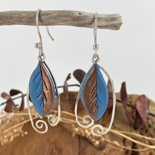 Blue with copper accents leaf hook earrings with hammered sterling silver swirled wires that frame the leaf.
