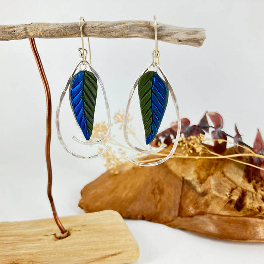 Stunning iridescent deep blue and green pointed leaf shaped earrings with sterling silver hammered wire frames.