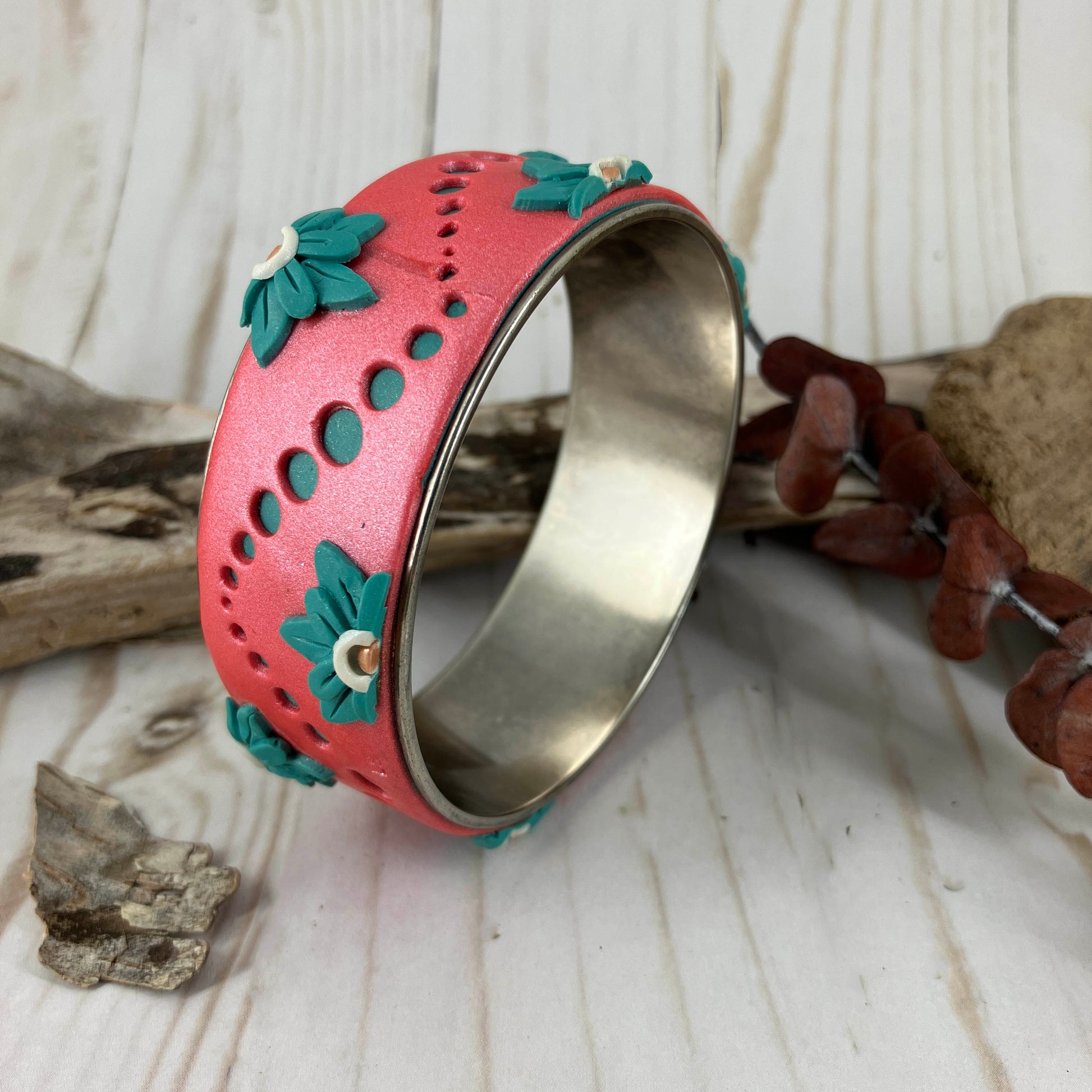 That summer feeling of turquoise dots of rolling waves across a silver bangle bracelet in a sunset color flagged by turquoise flower petals. Designed and handcrafted by Linda Stiles Smith 