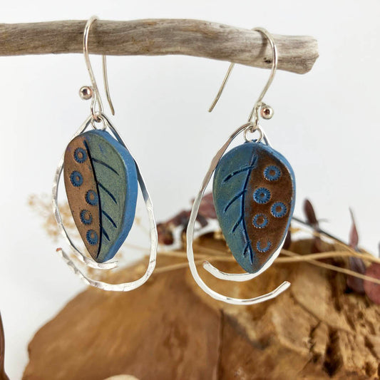 Dots adorn one side of these color shift leaf earrings. Sterling silver wire is shaped to surround them and dangle  in tandem with these colorful blue, copper and green earrings. 
