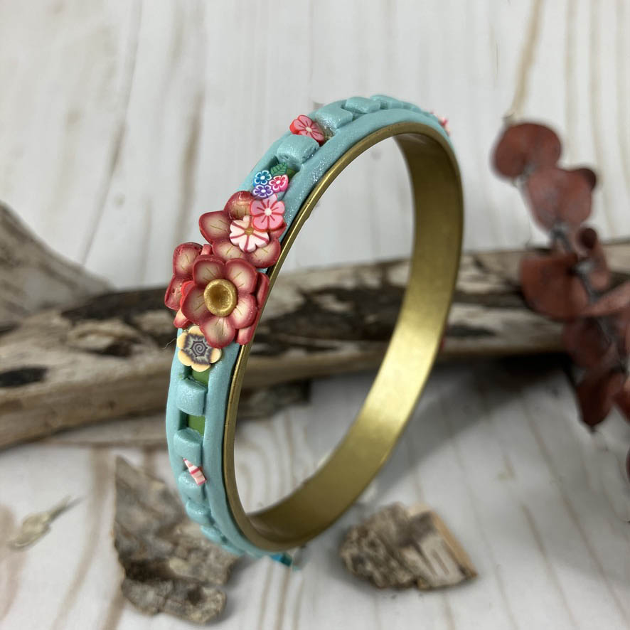 Flower cluster pops out of the blue band on brass bangle bracelet. Spring fun for special occasions stands out on any wrist. One of a kind art jewelry by Linda Stiles Smith of NatureScapes Studio.