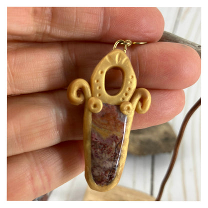 Golden picture jasper gemstone being held by the creator Linda Stiles Smith showing the size and detail of these one of a kind stones.