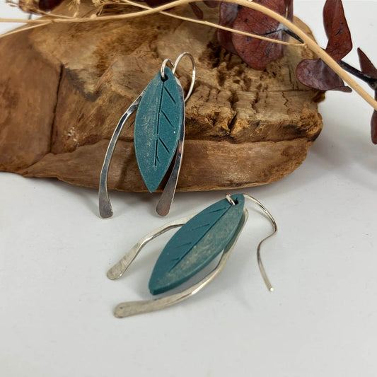 Gold dusted blue leaves captured with hammered sterling silver arches on both sides they are a one of a kind earring design by artist Linda Stiles Smith.
