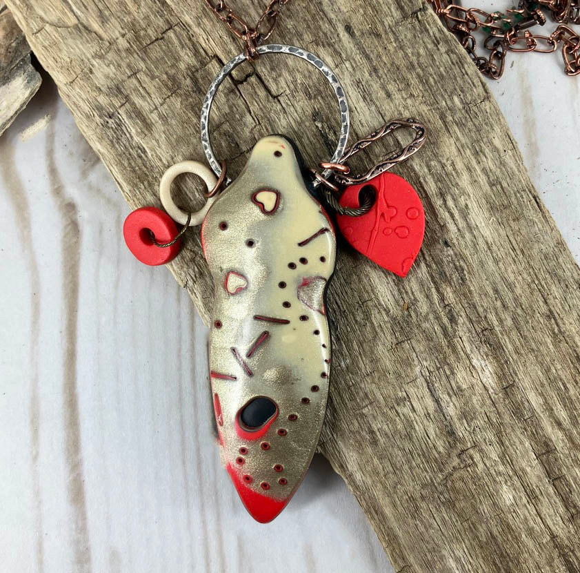 Female pendant in gold, red, and ivory on a metal ring and copper chain in unique mokume gane polymer clay. Original design by Linda Stiles Smtih.