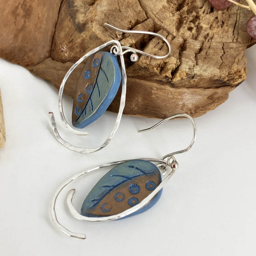 Color shifting from green to blue paired with copper and dots, these handcrafted earrings and one of a kind. Dotted Sterling silver hooks and hammered wires surround the focal leaves and play with each other with the movement of your head.