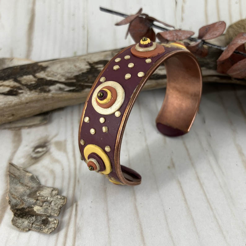 Copper cuff bracelet with dots of red, pearl, yellow and copper clay shown with both outer and inner surfaces