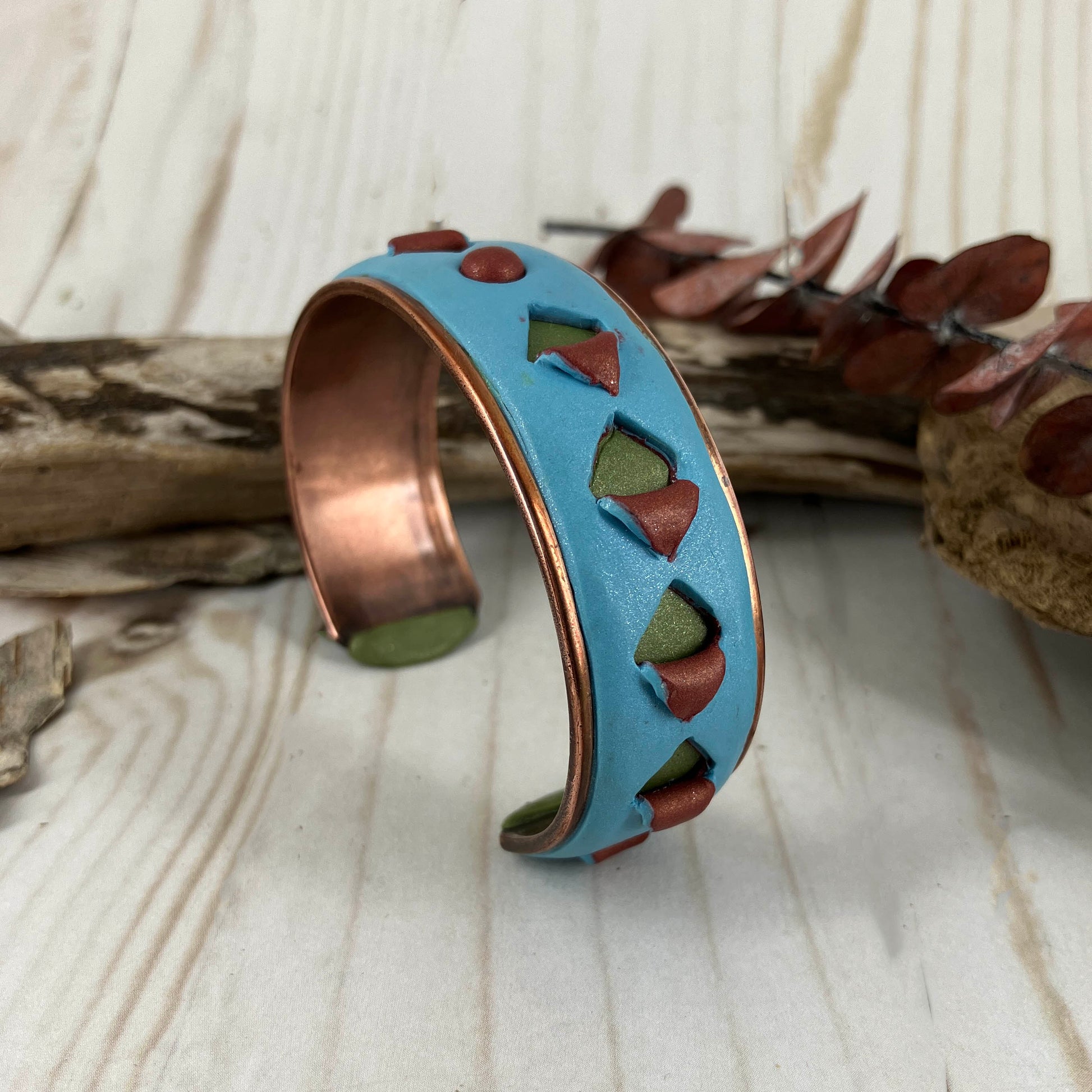 One of a kind cuff bracelt in blue and green on copper metal base with cut outs of green and copper . Handcrafted by Linda Stiles Smith 