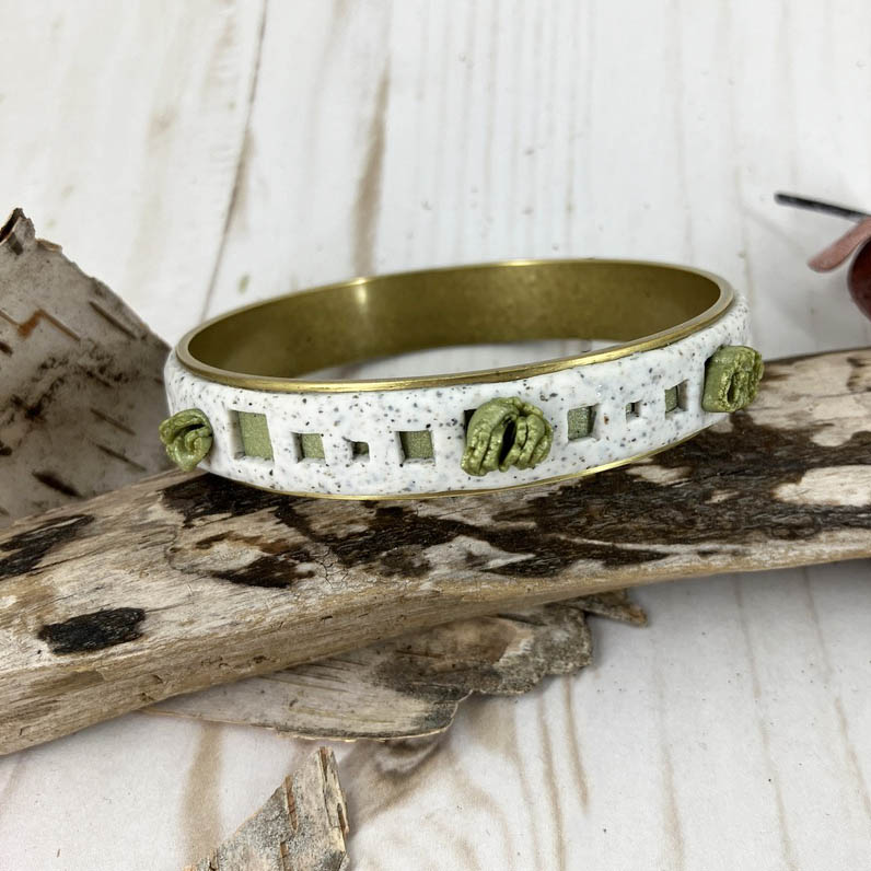 White granite open squares provide nooks for pops of  leaf green beneath and explosions of green clusters randomly placed all around. One of a Kind bangle designed by Linda Stiles Smith of NatureScapes Studio.