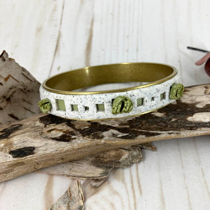 White granite open squares provide nooks for pops of  leaf green beneath and explosions of green clusters randomly placed all around. One of a Kind bangle designed by Linda Stiles Smith of NatureScapes Studio.