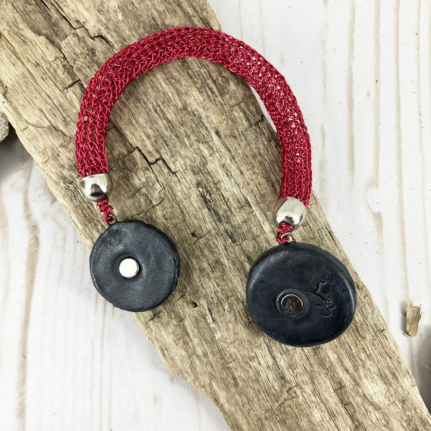 Open magnetic clasp set in polymer clay on one-of-a-kind viking knit bracelet. Handcrafted in polymer clay and red wire by Linda Stiles SMith