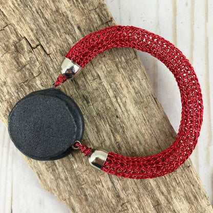 Back of red viking knit bracelet with a smooth back clasp of black polymer clay. Part of the collection at NatureScapes Studio.